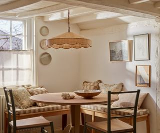 dining nook with built in seating, wooden table and chairs and large rafia pendant above table