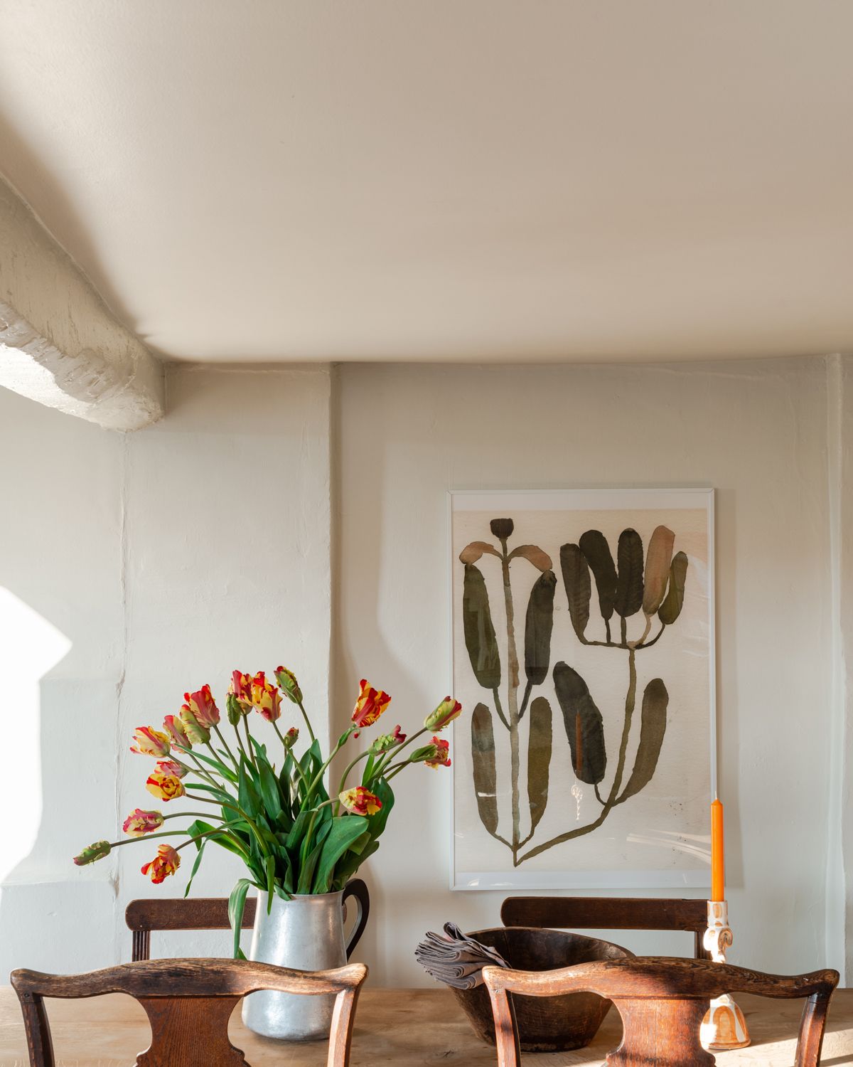 dining room area with artwork on white walls painted in Farrow & Ball's School House White paint color