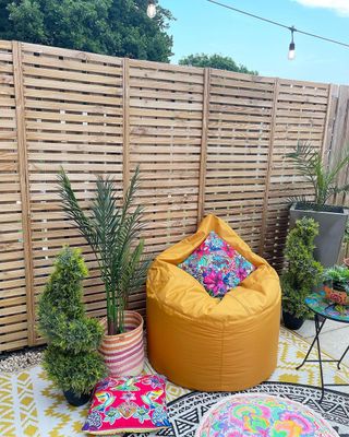 Backyard with wooden fence and yellow beanbag