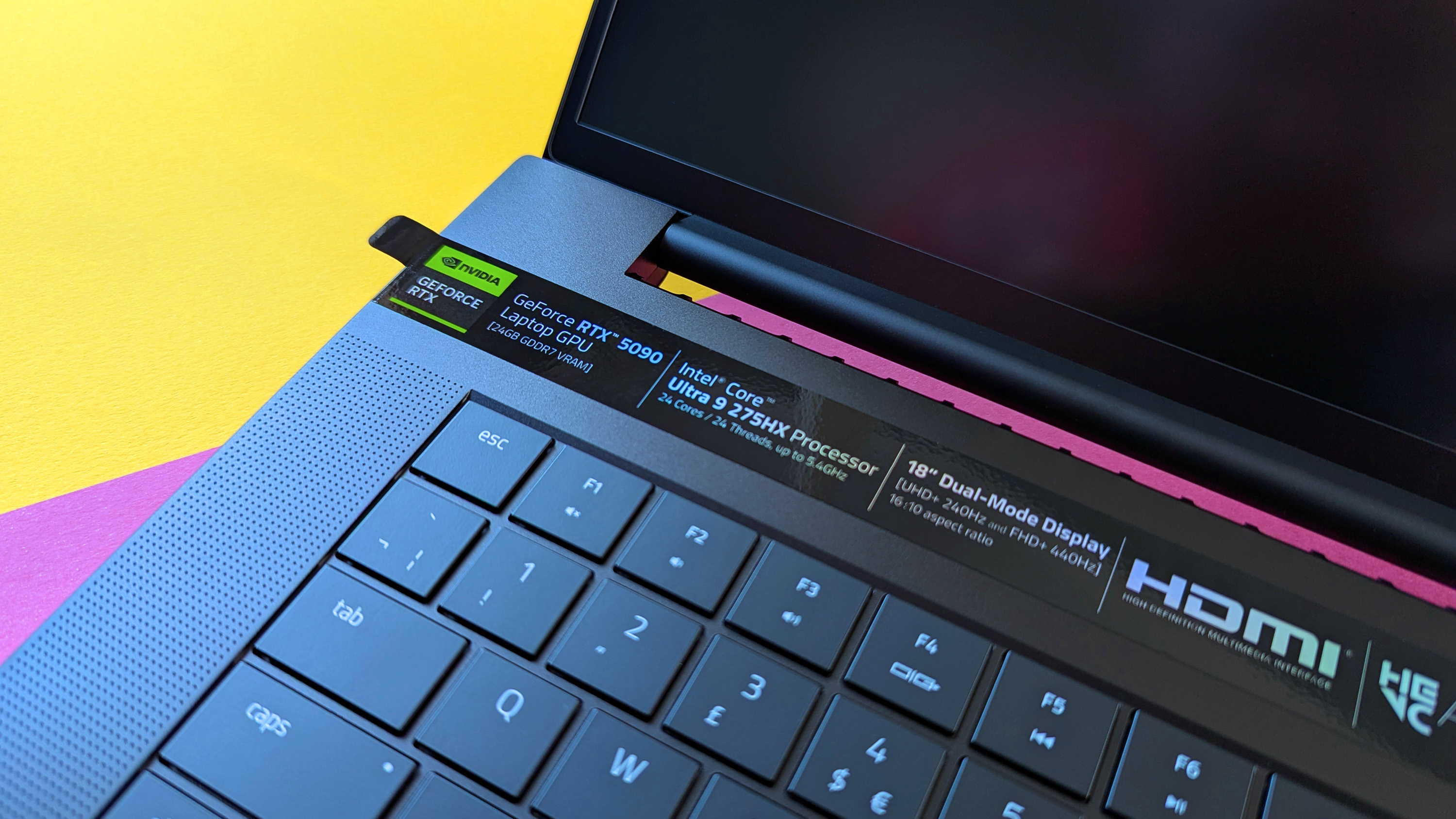 Razer Blade 18 (2025) gaming laptop on a pink and yellow background.
