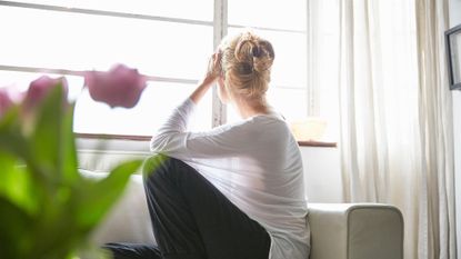 Woman sitting in front of window looking out