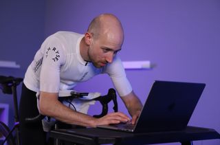 A close up shot of a rider selecting an indoor workout on a laptop