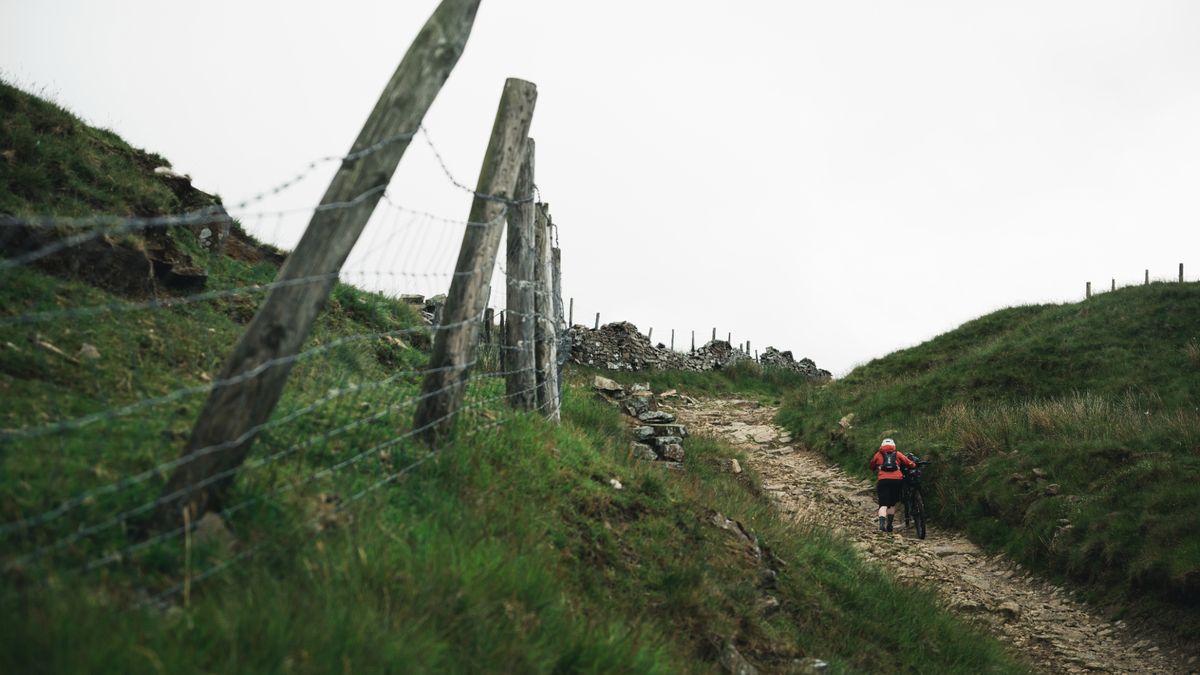 Cyclist pushes up a rocky path