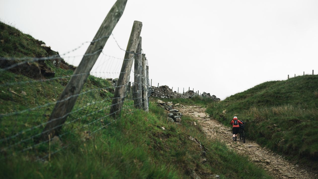 Cyclist pushes up a rocky path