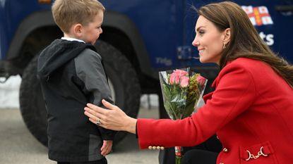 Britain's Catherine, Princess of Wales reacts as she is presented with a posy of flowers by four-year-old Theo Crompton during a visit to the RNLI (Royal National Lifeboat Institution) Holyhead Lifeboat Station in Anglesey, north west Wales on September 27, 2022.