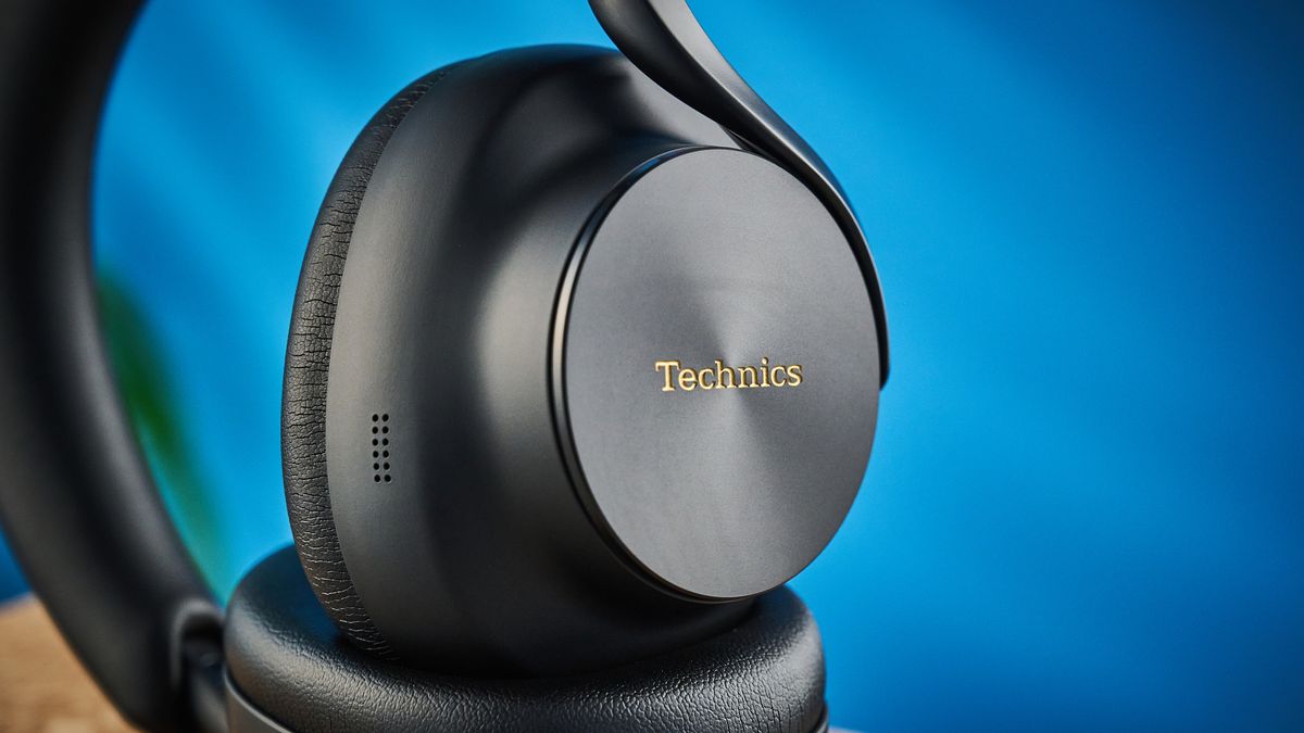 the technics eah-a1000 headphones with a gold technics logo photographed against a blue background