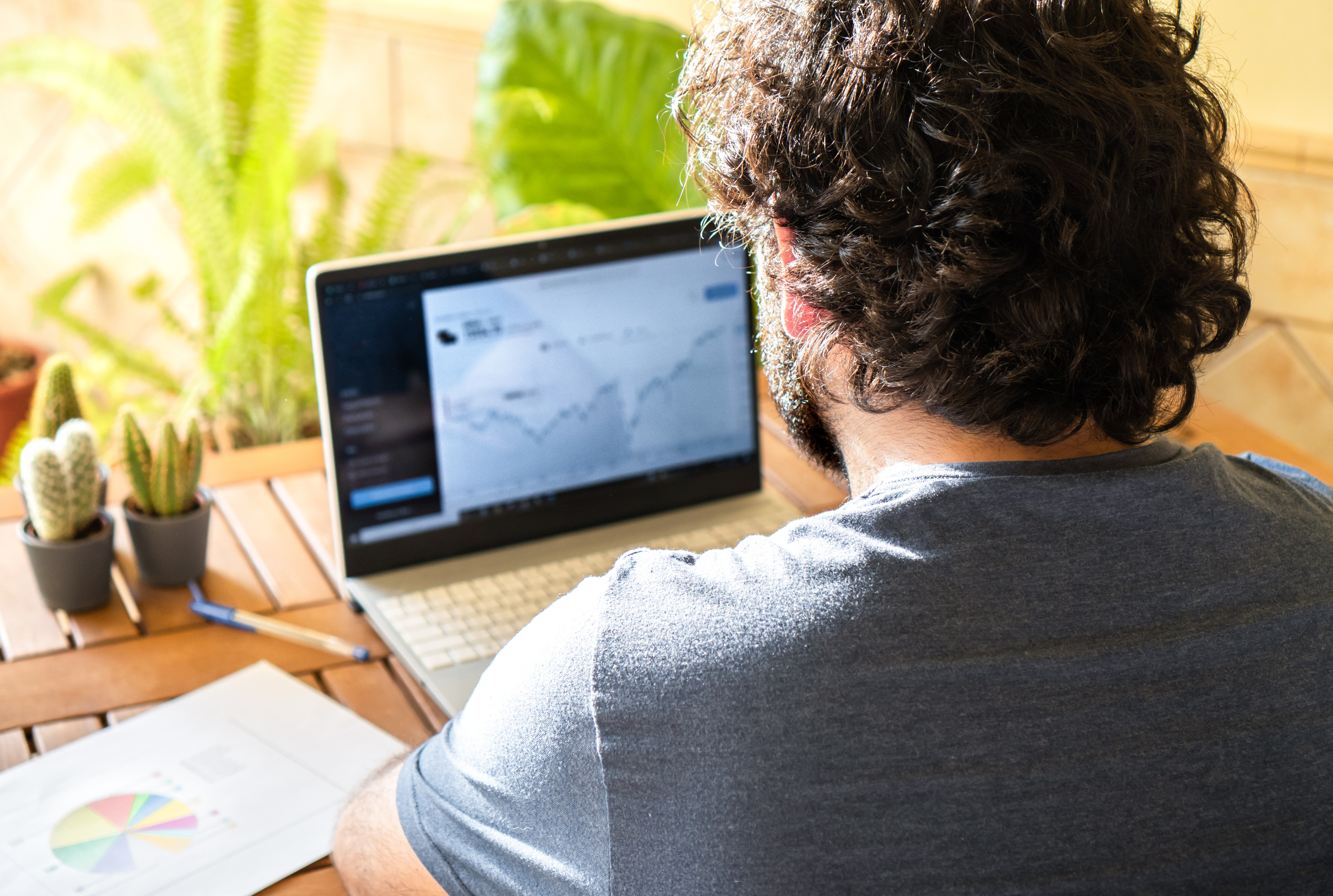 Man sitting at a table investing in active ETFs on a laptop