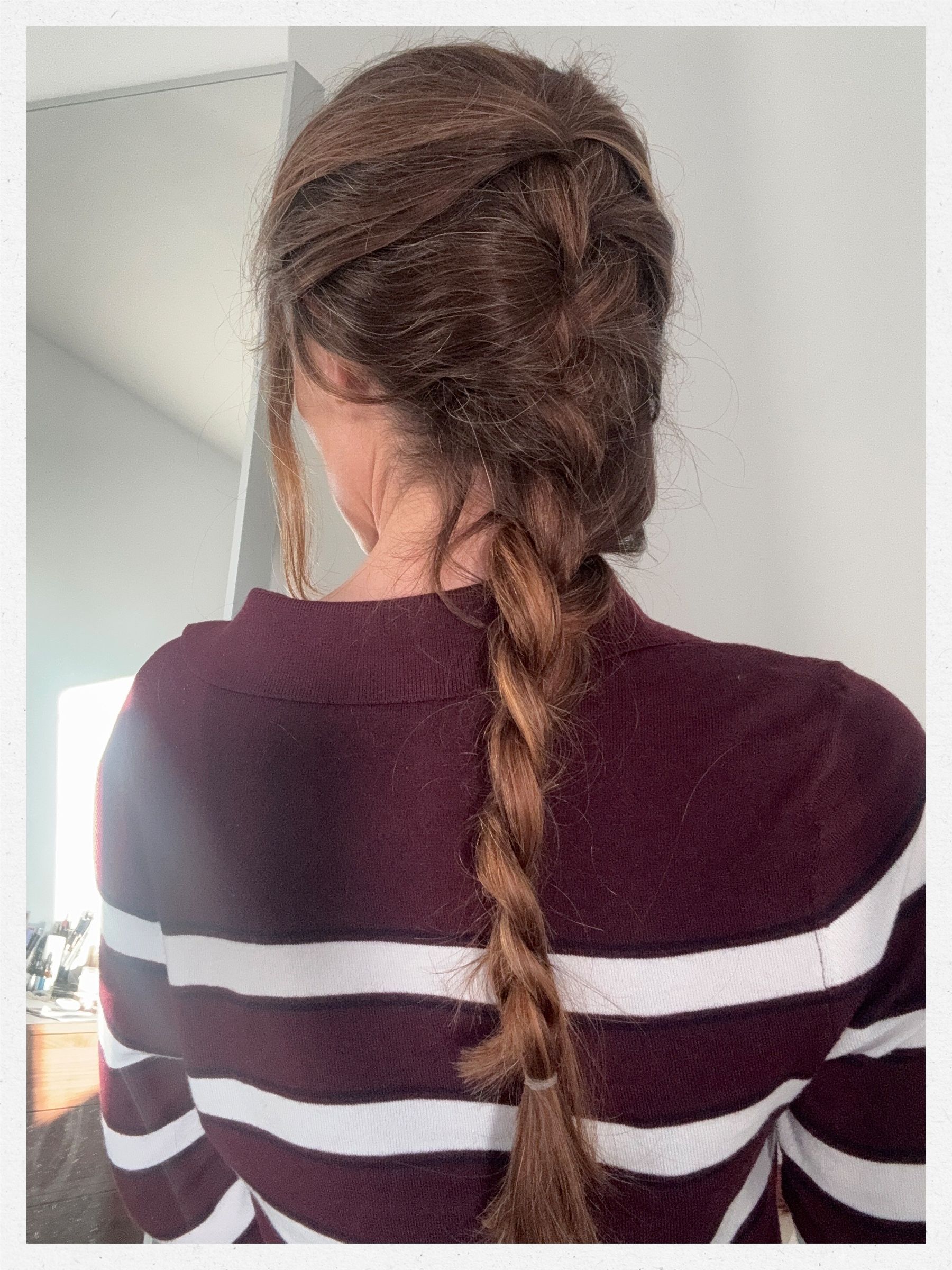 A photo of beauty editor Eleanor Vousden's hair in a French braid ponytail, photographed from the back to show the braided hairstyle