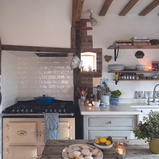 kitchen with white ties, aga, beams and open shelves