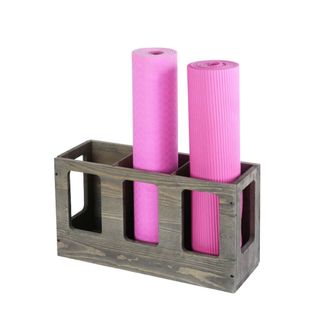 A dark brown yoga mat holder with two pink yoga mats
