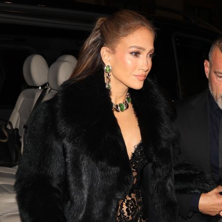Jennifer Lopez in Milan wearing a black lacy lingerie slip as a naked dress with a fur coat to attend a Dolce and Gabbana party