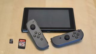 Nintendo Switch next to microSD card and cartrdige
