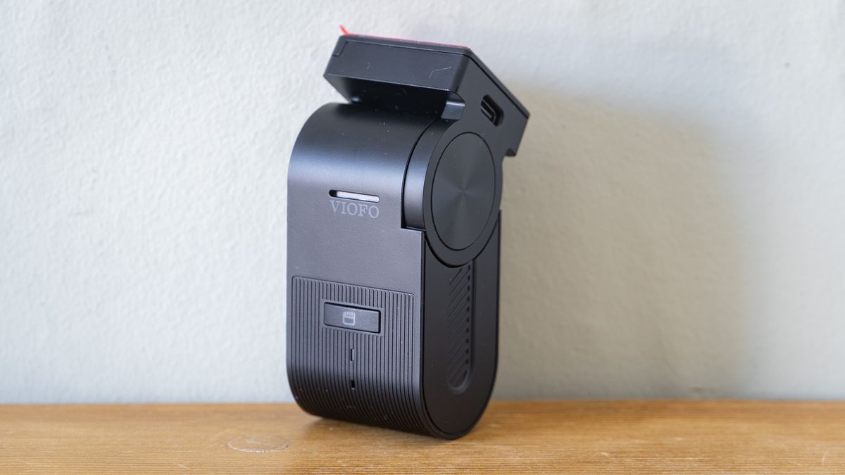 Viofo VS1 dashcam on a wooden table in front of a white wall