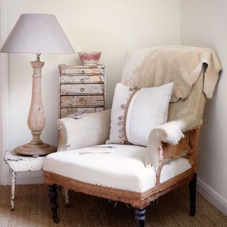 living room with white wall armchair with designed cushion and lamp