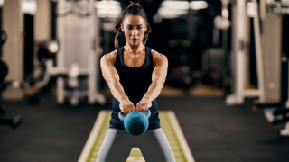 A woman performing a kettlebell swing