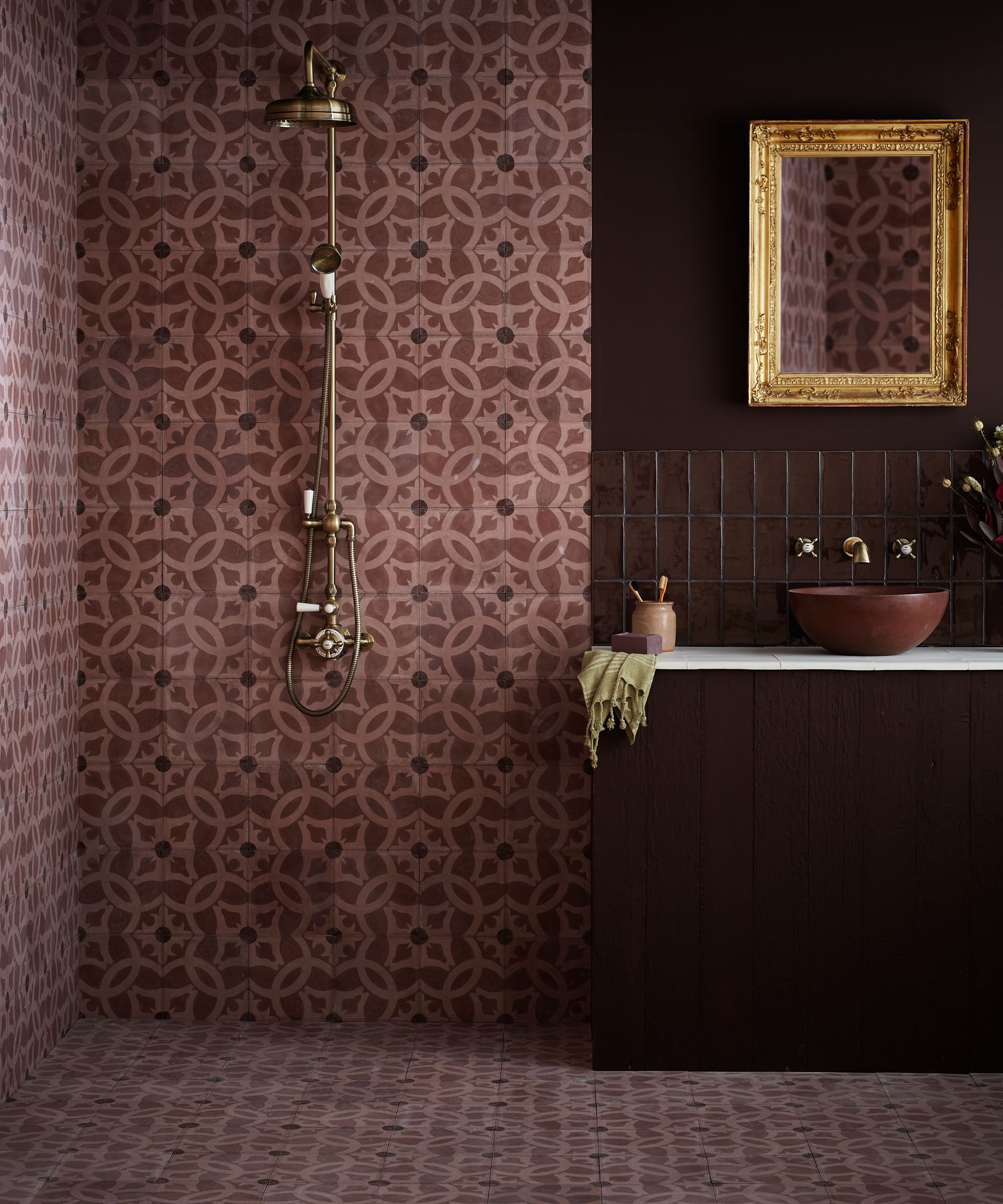 A bathroom with dark red tiles