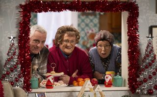 Mrs Brown peeping through her kitchen hatch with Winnie on her left and Mark on her right.