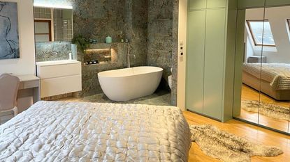 en suite with freestanding bath and marble tiles