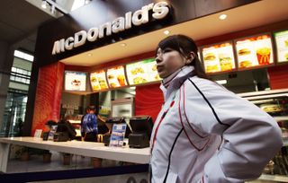 olympic athlete stands next to mcdonalds