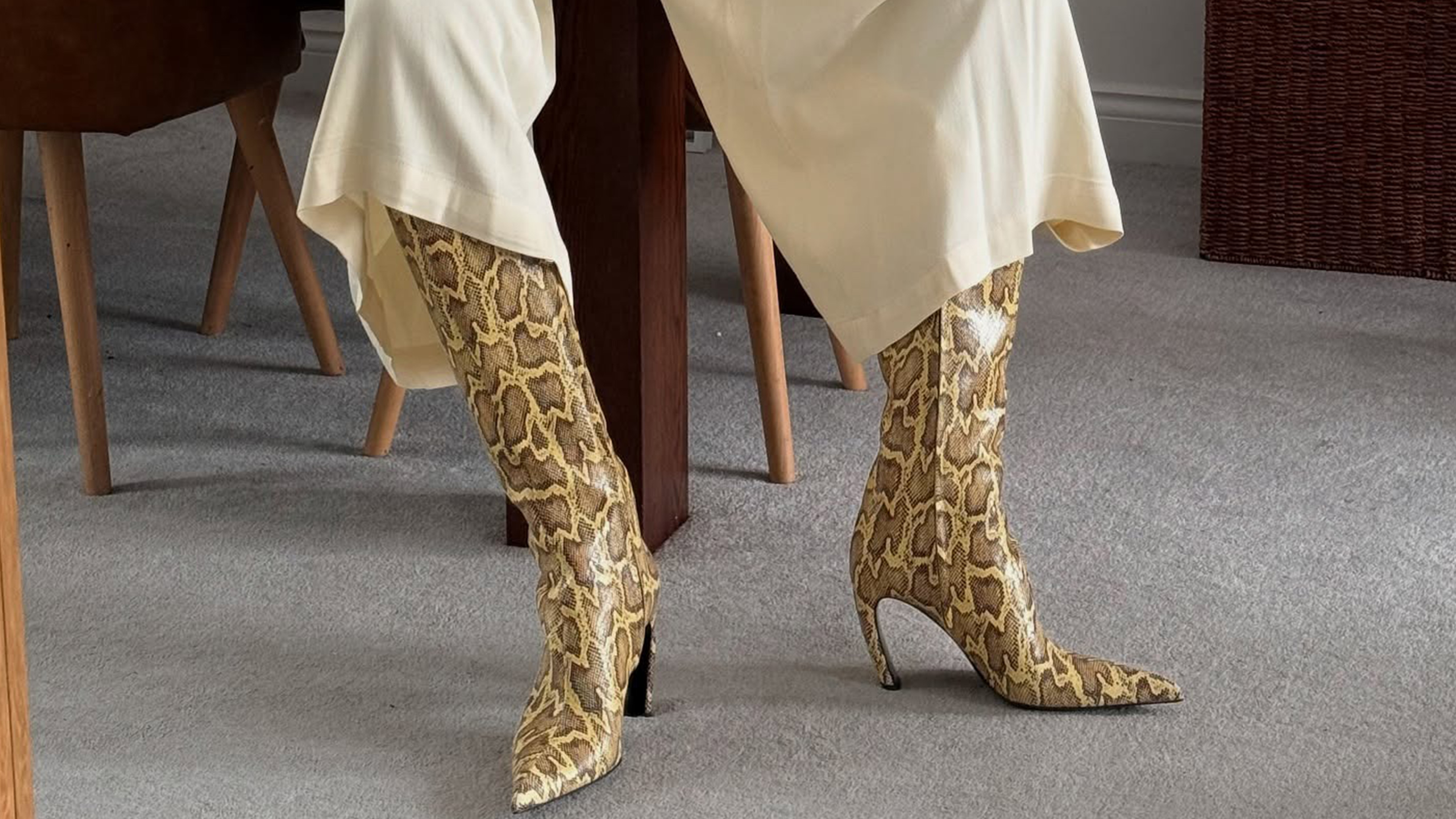 Marilyn wears ivory silk pants and yellow snakeskin heeled boots.