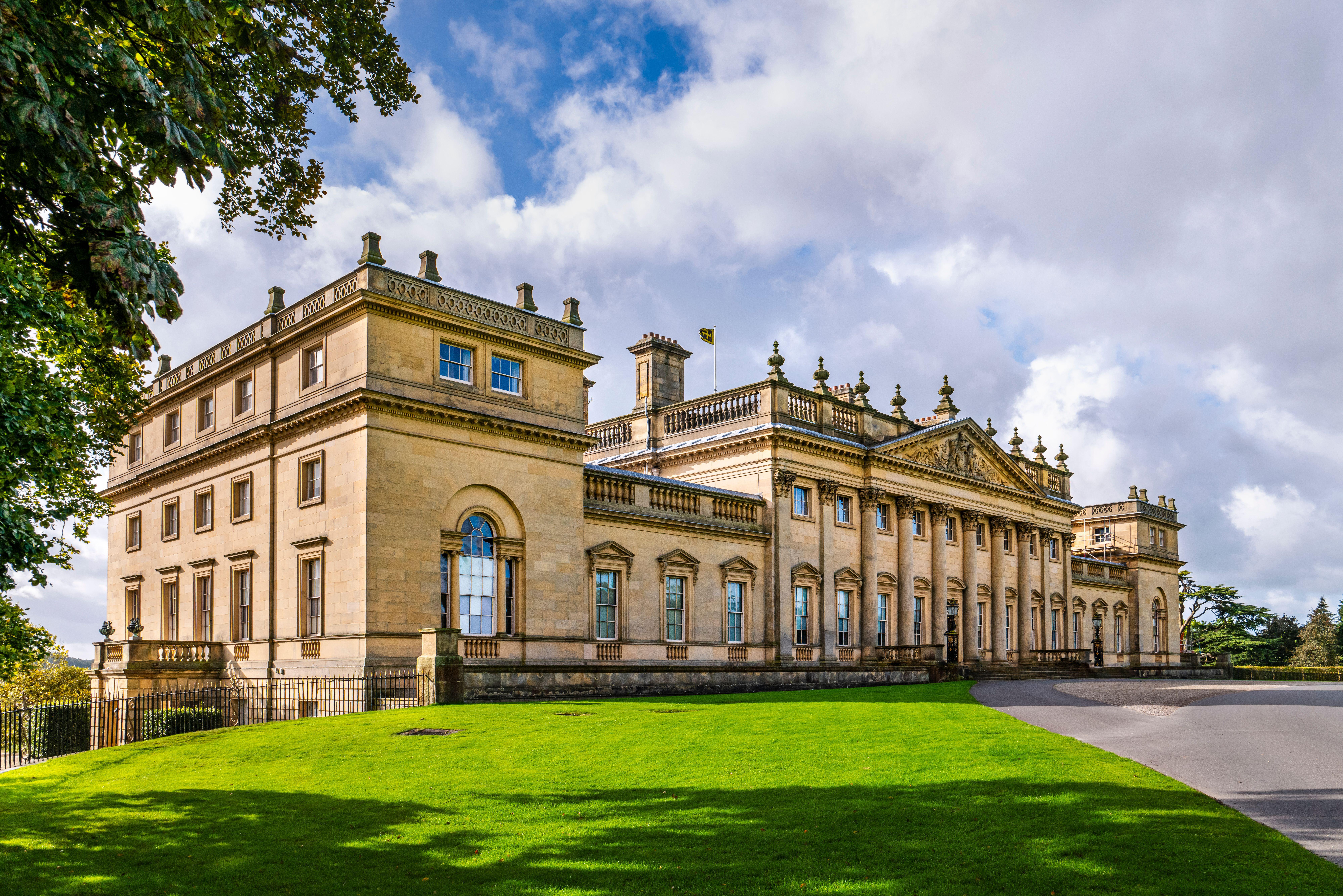 The front of a great country house, showing it's classical forms and golden stone.