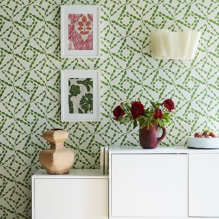 Green wallpaper with print in white frames