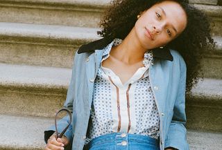 Woman in blue coat and print shirt.