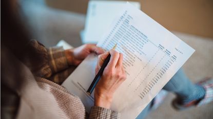 A checklist is held in a woman's hands.