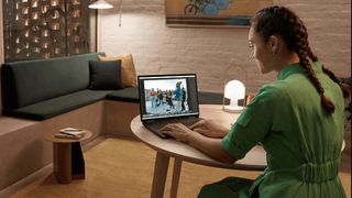 Woman using the HP Spectre x360 on a brightly lit desk in a room. 