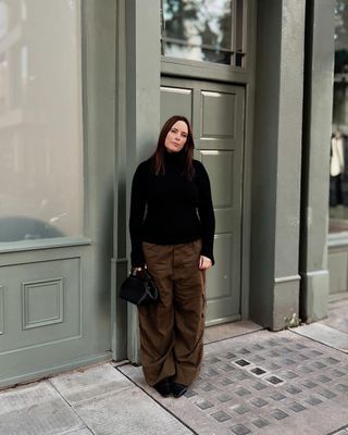 @annacascarina wearing a black turtleneck and cargo pants