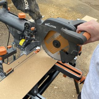 a chop saw cutting a piece of mdf paneling