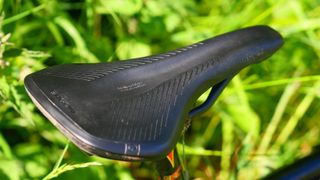 Ergon SR All-Road Core Pro Carbon gravel saddle pictured from behind against grass