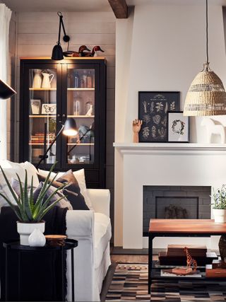 A cream living room with bold black accents through furniture frames and shelving