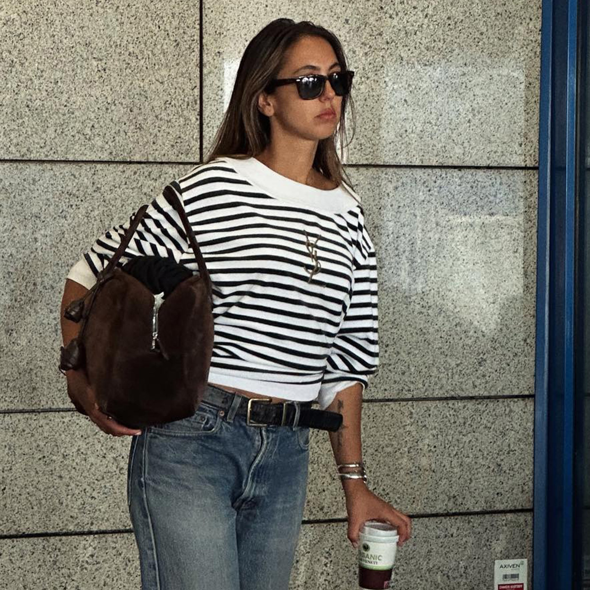 Hanna MW wearing a striped YSL shirt with a brown suede bag and jeans.