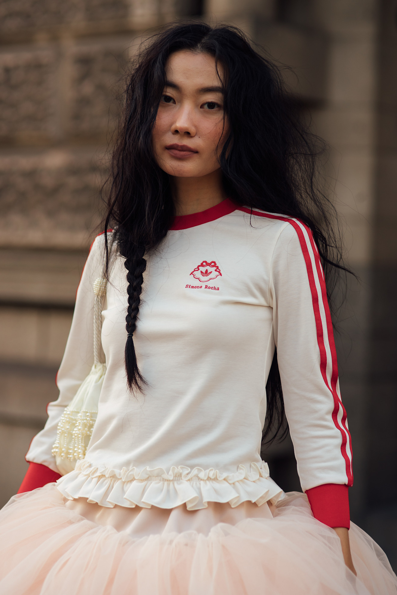 an asian woman with long braided hair in a red and white shirt