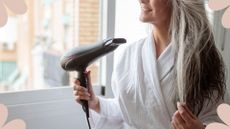 Woman blow drying her hair at a window