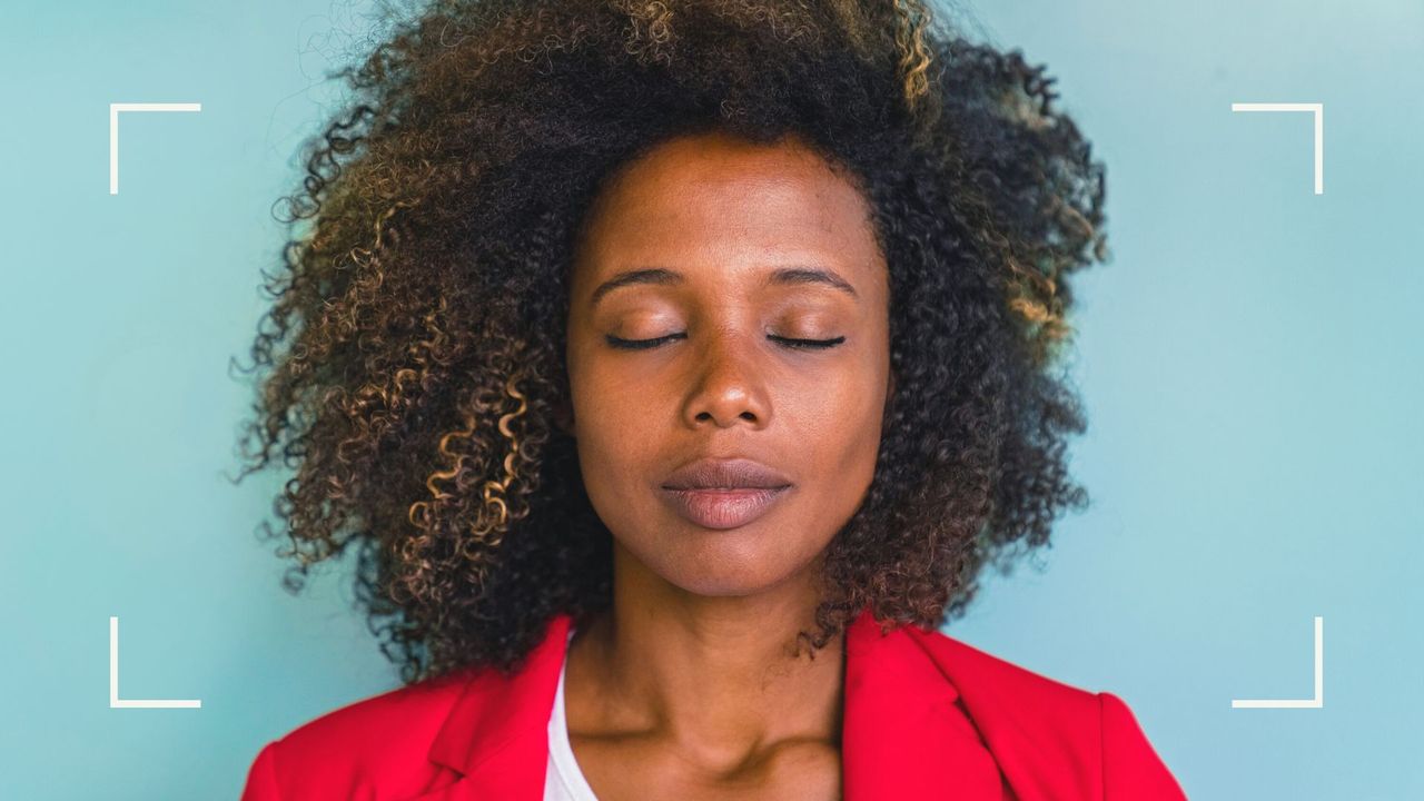 woman with eyes closed manifesting, an image used to accompany a woman&amp;home article on &#039;best manifestation methods for beginners&#039;