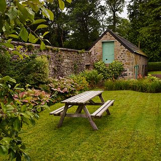 garden area with old stone bothy and flower plants