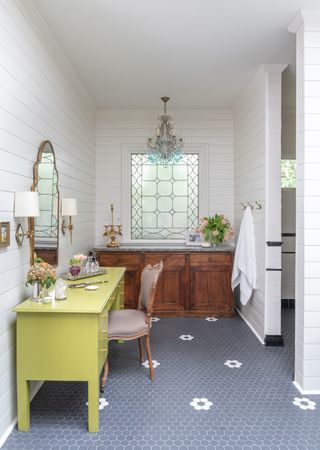 make up room with acid yellow vanity, tiled floor, sideboard, shiplap walls next to bathroom