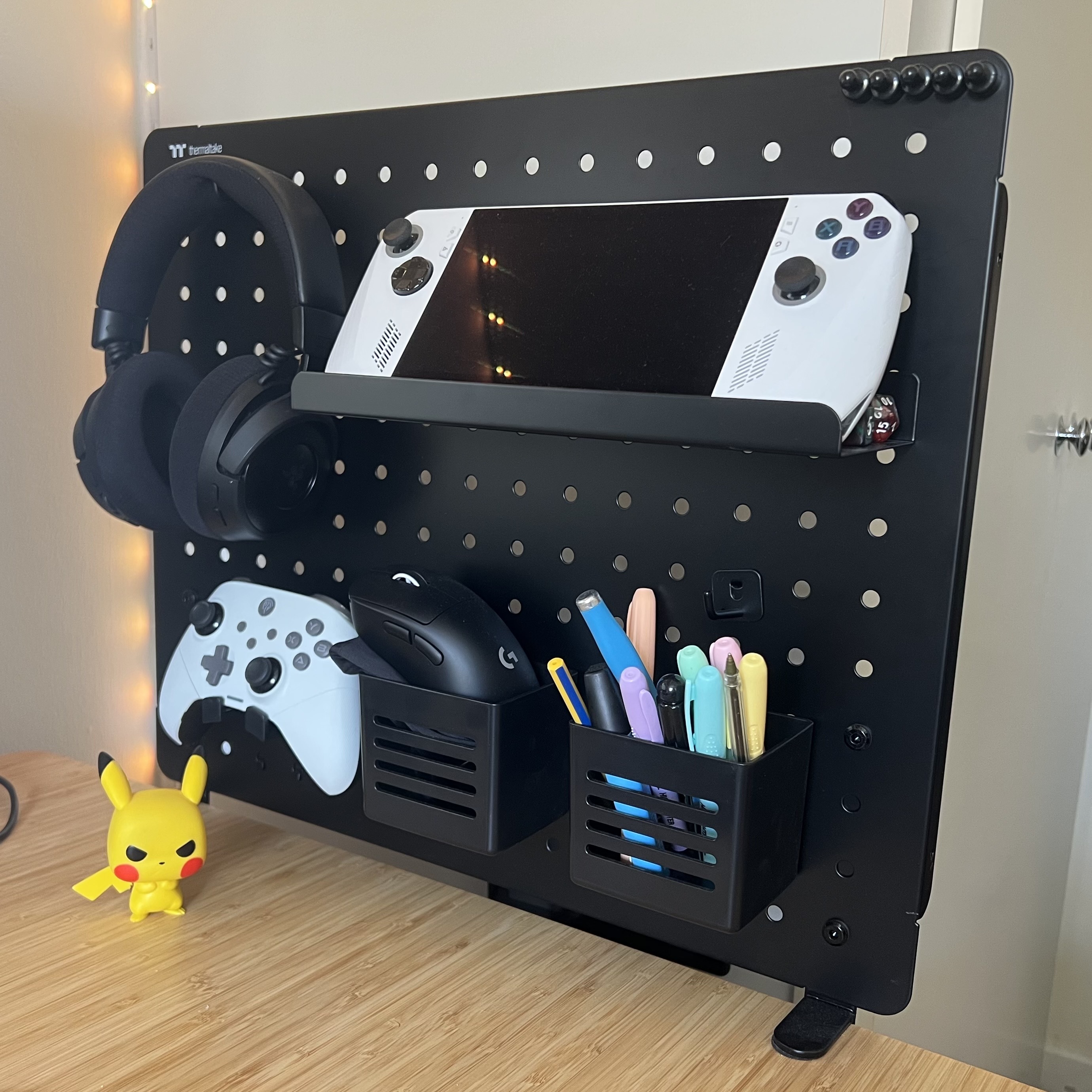 A black pegboard attached to a desk with accessories attached