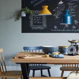 dining area with chalkboard and wooden dining table with chairs