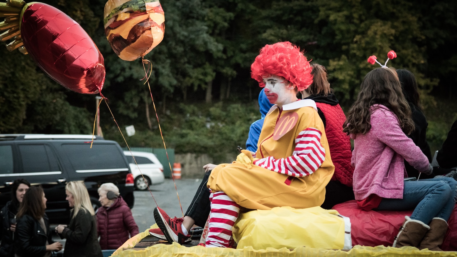 A picture of a child dressed as Ronald McDonald looking sad
