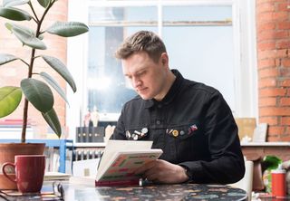 Craig Oldham reading at his desk