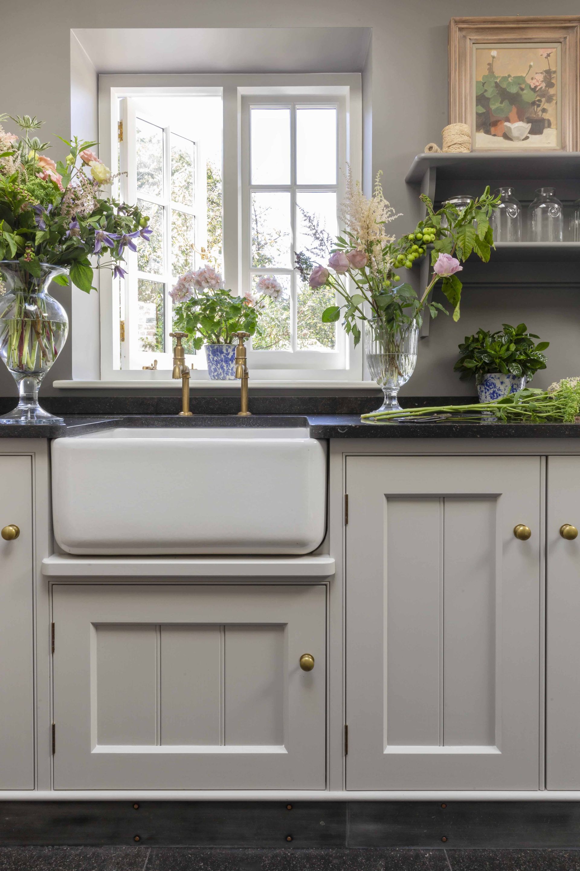 Grey base cabinets, shelves and walls, black kitchen worksurface and flooring