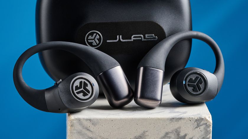 Jlab epic open sport open-earbuds in a black colorway photographed on a blue background.