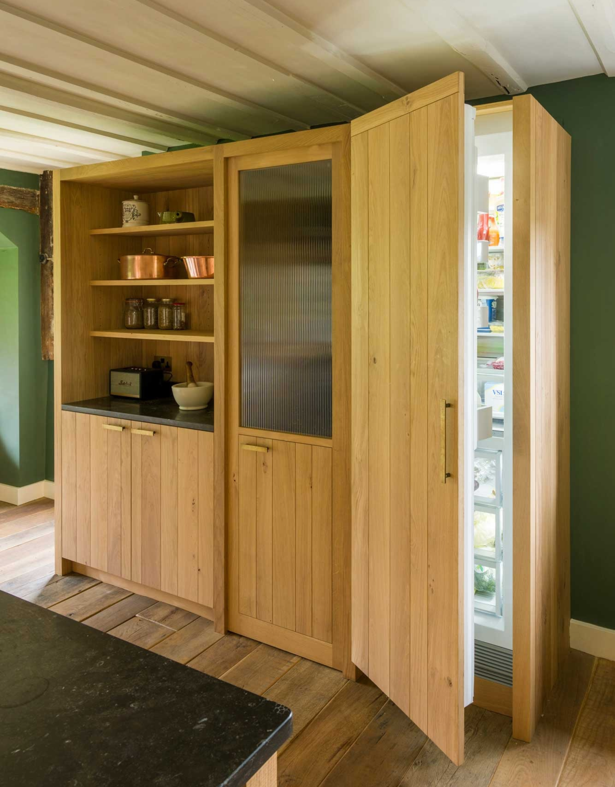 wooden structure in kitchen with storage, a concealed fridge and a hidden pantry room within