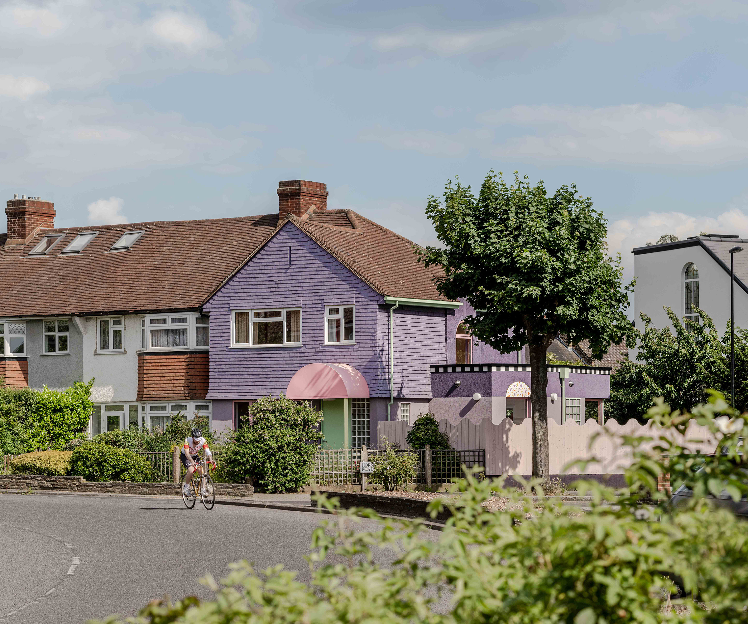 Exterior shot of an end of terrace 1950s house painted purple after a renovation
