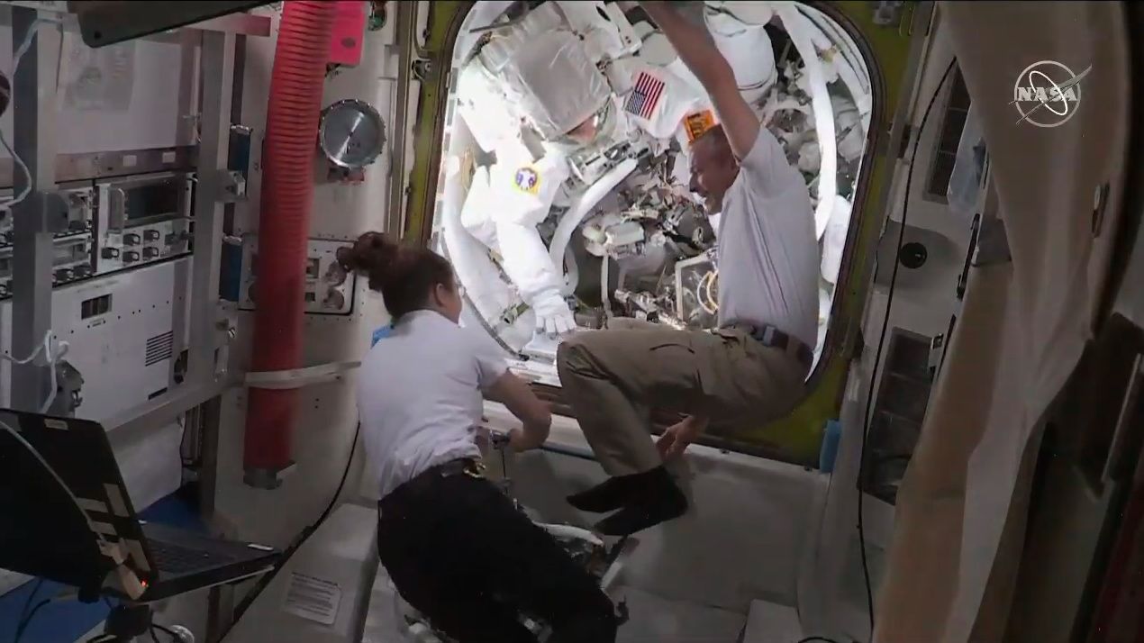Canadian Apace Agency astronaut David Saint-Jacques and NASA astronaut Christina Koch open the hatch to the Quest airlock to let their spacewalking colleagues back inside the space station.