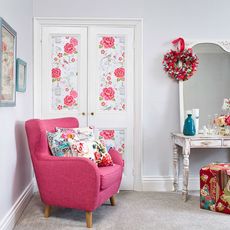 bedroom with pink arm chair and dressing table