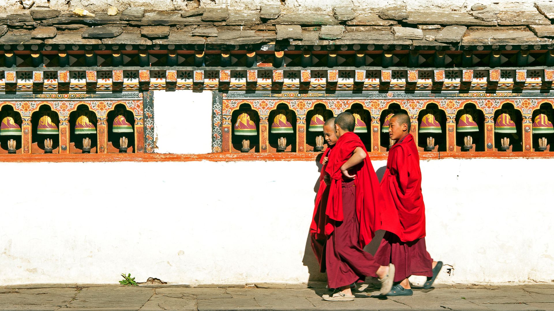 novice monks walking in front of a templs